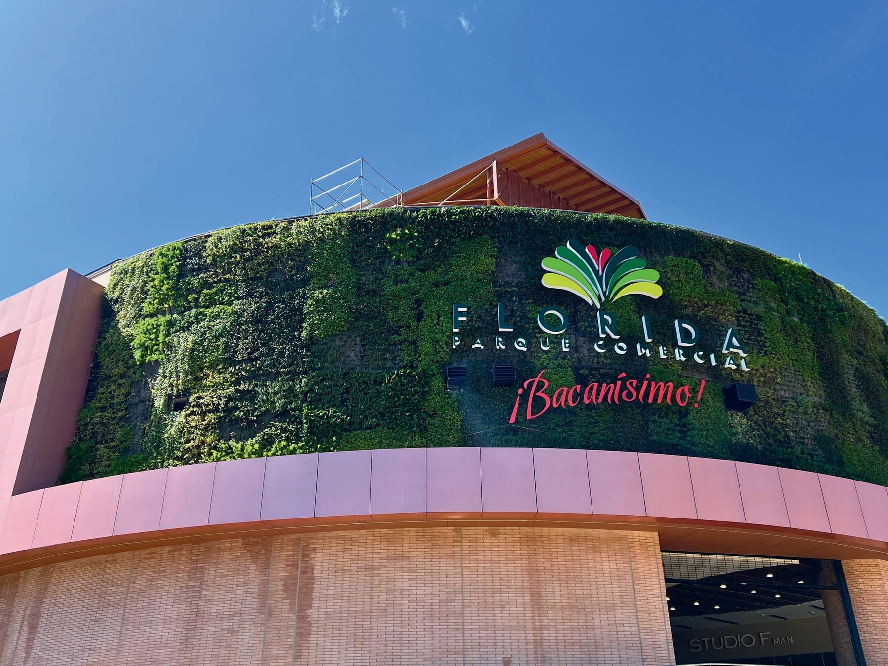 Fachada curva con el nombre del centro comercial; el jardín vertical lo construyó otra empresa y Follajes se encarga de su mantenimiento